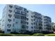 White condo building featuring multiple stories with large windows, balconies, and well-maintained landscaping at 200 N Betty Ln # 5F, Clearwater, FL 33755