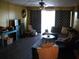 Cozy living room featuring dark wood floors, brown sofa, decorative curtains, and a ceiling fan at 200 N Betty Ln # 5F, Clearwater, FL 33755