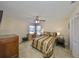 Bedroom featuring carpeted floors, a ceiling fan, two windows and a wooden dresser at 2004 Berry Roberts Dr, Sun City Center, FL 33573