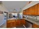 Bright kitchen featuring granite countertops, wooden cabinets, and stainless steel dishwasher at 2004 Berry Roberts Dr, Sun City Center, FL 33573