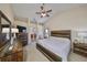 Spacious main bedroom featuring a ceiling fan, a wooden bed frame, and plenty of natural light at 2004 Berry Roberts Dr, Sun City Center, FL 33573