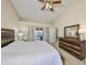 Serene main bedroom with a wood bed frame, dresser, and slider door access to the sunroom at 2004 Berry Roberts Dr, Sun City Center, FL 33573
