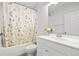 Clean bathroom with a tub and shower, a floral shower curtain, a modern vanity, and ample natural light at 20203 Merry Oak Ave, Tampa, FL 33647