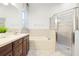 Well-lit bathroom featuring double sinks, a soaking tub, a separate shower, and neutral tile at 20203 Merry Oak Ave, Tampa, FL 33647