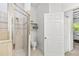 Stylish bathroom featuring a glass-enclosed shower, neutral tile, and a convenient toilet area with built-in shelving at 20203 Merry Oak Ave, Tampa, FL 33647