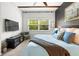 Bright bedroom with a large window, soft carpet, mounted television, ceiling fan, and stylish dark accent wall at 20203 Merry Oak Ave, Tampa, FL 33647