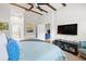 Comfortable bedroom offering a ceiling fan, mounted television, stylish furniture, and access to an en-suite bathroom at 20203 Merry Oak Ave, Tampa, FL 33647