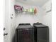 Laundry room with black Samsung washer and dryer, white walls, and shelving for storage at 20203 Merry Oak Ave, Tampa, FL 33647