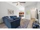 Spacious living room featuring a comfortable blue sofa, modern ceiling fan, and an open floor plan leading to the kitchen at 20203 Merry Oak Ave, Tampa, FL 33647