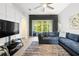 Bright living room with a blue sectional, large windows, and access to outdoor living space at 20203 Merry Oak Ave, Tampa, FL 33647