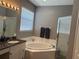 Bright bathroom with large tub, walk-in shower, and granite counters at 2111 Park Crescent Dr, Land O Lakes, FL 34639