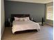 Comfortable bedroom with wood floors, gray accent wall, and large bed at 2111 Park Crescent Dr, Land O Lakes, FL 34639