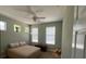Bright bedroom featuring wood floors, ceiling fan, and two windows at 2111 Park Crescent Dr, Land O Lakes, FL 34639