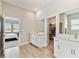 Bright bathroom featuring a double vanity, a walk-in closet, an entrance to the Primary bedroom, and wood-look tile flooring at 21506 Snowy Orchid Ter, Land O Lakes, FL 34637