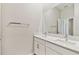 Bright bathroom with double sinks, quartz countertops, white cabinets, and a large mirror at 21506 Snowy Orchid Ter, Land O Lakes, FL 34637