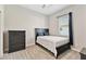 Charming bedroom with a dark wood bed frame, dresser, carpeted floor, and a window for natural light at 21506 Snowy Orchid Ter, Land O Lakes, FL 34637