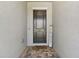 Home's entryway with a covered porch, brick flooring, and a welcoming 'Home Sweet Home' sign at 21506 Snowy Orchid Ter, Land O Lakes, FL 34637