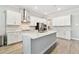 Modern kitchen with an island, stainless appliances, white cabinets and subway tile backsplash at 21506 Snowy Orchid Ter, Land O Lakes, FL 34637