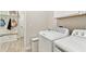 Mudroom with a laundry area, wood-look tile flooring, built-in bench, and white cabinets at 21506 Snowy Orchid Ter, Land O Lakes, FL 34637