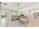 Open floorplan with tile flooring, a large sectional sofa, and a view to kitchen and lanai at 21506 Snowy Orchid Ter, Land O Lakes, FL 34637