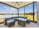 Covered patio with a view of the water, seating and a coffee table with wicker furniture and brick flooring at 21506 Snowy Orchid Ter, Land O Lakes, FL 34637