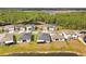 Aerial view of several homes, showing lawn and covered patio near a pond at 21506 Snowy Orchid Ter, Land O Lakes, FL 34637