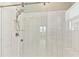 Luxurious walk-in shower featuring modern chrome fixtures, vertical subway tiles, and a built-in bench seat for comfort at 21506 Snowy Orchid Ter, Land O Lakes, FL 34637