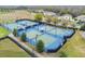 Aerial view of community tennis and basketball courts provides an active lifestyle with mature trees and homes nearby at 21506 Snowy Orchid Ter, Land O Lakes, FL 34637
