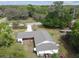 A bird's-eye view reveals the home's unique layout, surrounded by lush greenery and a lengthy drive at 2231 Nichols Rd, Lithia, FL 33547