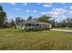 Quaint single-story home with an inviting front porch, surrounded by lush greenery and a freshly mowed lawn at 2231 Nichols Rd, Lithia, FL 33547
