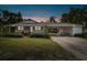 Charming home at dusk featuring a covered carport, and well-maintained lawn and landscaping at 2231 Nichols Rd, Lithia, FL 33547
