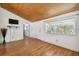Bright living room featuring wood-look floors, a large window, and a mounted television at 2231 Nichols Rd, Lithia, FL 33547