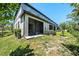 Backyard view of a screened patio and lush lawn, perfect for enjoying the outdoors and entertaining guests at 23378 Papyrus Way, Lutz, FL 33549