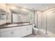 Bathroom with double sinks, white cabinets, and tiled shower at 23378 Papyrus Way, Lutz, FL 33549