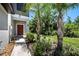 Inviting front entrance with a stylish door, complemented by manicured greenery and palm trees at 23378 Papyrus Way, Lutz, FL 33549