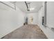 Attached garage with concrete flooring, overhead lighting, and white-painted walls providing a clean and functional space at 23378 Papyrus Way, Lutz, FL 33549