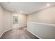 Upstairs hallway with neutral carpet, wall color, and white trim creates a bright and airy transitional space at 23378 Papyrus Way, Lutz, FL 33549