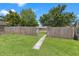 Fenced backyard with a grassy lawn and mature trees at 2450 3Rd N Ave, St Petersburg, FL 33713