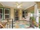 Inviting covered front porch boasts a swing, ceiling fan, and colorful pineapple patterned outdoor rug at 2450 3Rd N Ave, St Petersburg, FL 33713