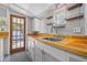 Close-up view of a sink area in a kitchen featuring butcher block countertops and white cabinets at 2450 3Rd N Ave, St Petersburg, FL 33713