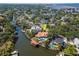 Aerial view of a waterfront property with a pool, boat dock, lush landscaping, and stunning water views at 2512 S Dundee St, Tampa, FL 33629