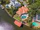 An aerial view of a waterfront property with a pool and boat lift showcases the desirable location at 2512 S Dundee St, Tampa, FL 33629