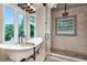 Modern bathroom featuring a soaking tub, glass enclosed shower, tile walls and a large window at 2512 S Dundee St, Tampa, FL 33629