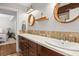 Modern bathroom with double sinks, quartz counters, wood cabinets, and decorative round mirrors at 2512 S Dundee St, Tampa, FL 33629