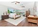Bright bedroom featuring hardwood floors, area rug, seating and a decorative ceiling fan at 2512 S Dundee St, Tampa, FL 33629