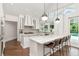Bright kitchen boasts marble counters, an island with seating, and stainless steel appliances, overlooking the pool area at 2512 S Dundee St, Tampa, FL 33629