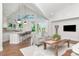 Bright living room featuring vaulted ceilings, hardwood floors, and open view to kitchen at 2512 S Dundee St, Tampa, FL 33629