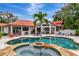 Beautiful pool and backyard featuring a hot tub, mature trees, and spacious patio with outdoor seating at 2512 S Dundee St, Tampa, FL 33629
