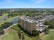Aerial view of condominium building overlooking the golf course, pond, and adjacent community at 2616 Cove Cay Dr # 803, Clearwater, FL 33760