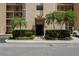 Front view of building with well-manicured landscaping and palm trees. Unit number above entrance at 2616 Cove Cay Dr # 803, Clearwater, FL 33760